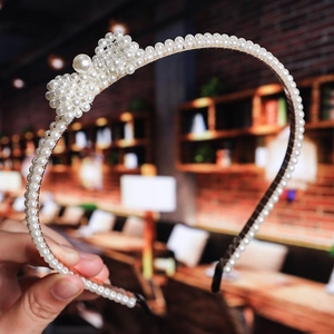 Macro detail of handcrafted pearl headband with elegant bow design on gold frame