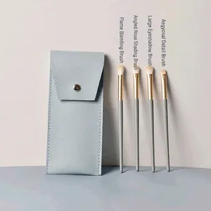 Détail de 4 pinceaux à paupières aux poils souples avec une pochette en cuir bleu