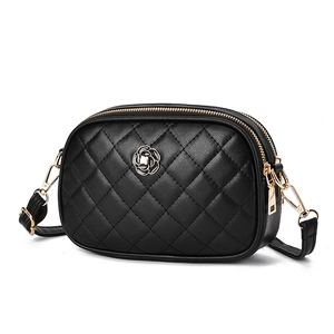 Classic black quilted crossbody camera bag featuring a gold camellia logo on white background