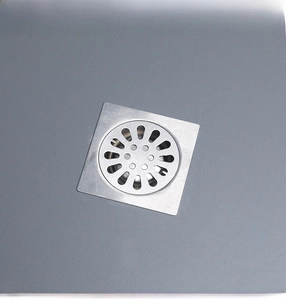Close-up of square stainless steel floor drain with round perforated grate for bathroom