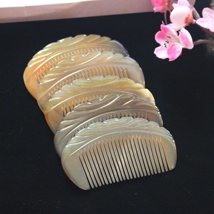 Detailed view of four carved yak horn combs with leaf patterns and natural textures