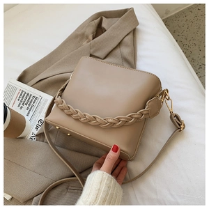 Chic khaki PU leather handbag with woven handle on a bed for a stylish morning scene
