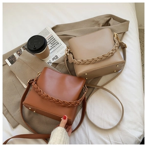 Detail of khaki and caramel PU leather bucket bags with stylish woven top handles