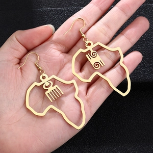 Macro view of gold African map earrings with traditional Adinkra Gye Nyame symbols