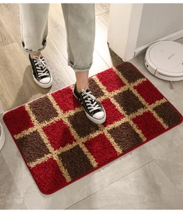 Detail of red and brown checkered entryway mat featuring soft absorbent plush texture