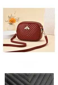 Detailed close-up of burgundy quilted leather bag with a gold bee metal buckle