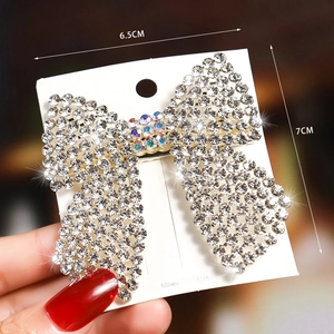 Detail of a butterfly hair clip with sparkling rhinestones and a pearl center on card
