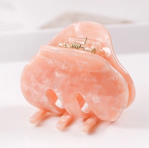 Close-up of pink marbled acetate hair claw clip with a durable gold metal spring