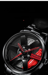 Macro shot of 3D racing wheel rim watch dial with red brake caliper and black metal strap