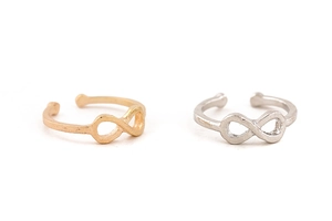 Detail of minimalist gold and silver infinity symbol open rings on white background