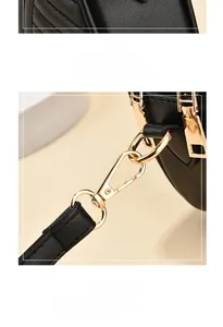 Detail of golden mirror zipper and rotating metal clasp on black lychee leather bag