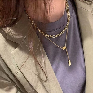 Detail view of double layered gold titanium necklace on professional workwear model