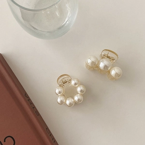 Close-up of elegant small pearl hair clips in round and linear minimalist designs