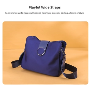 Detail of navy nylon crossbody bag featuring wide shoulder strap and silver metal ring hardware