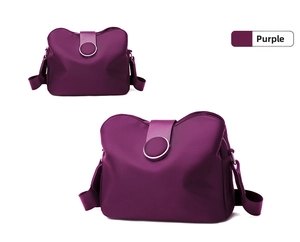 Detail of two purple nylon mini crossbody bags with adjustable straps and round magnetic clasps