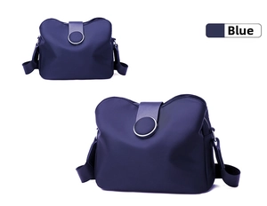 Detail view of the navy blue mini crossbody bag with silver ring clasp and nylon texture