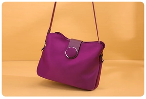 Detail of trendy purple nylon mini crossbody bag with a metallic magnetic buckle closure