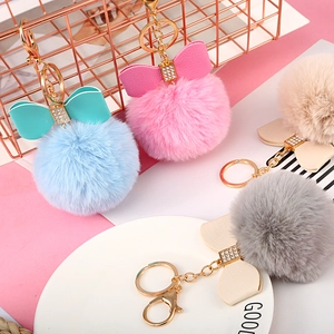 Close-up of 8cm plush pom pom keychains with bowknot and gold lobster clasp