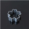Close-up of a silver flower shaped metal cookie cutter on a black reflective surface