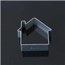 Macro shot of a house-shaped cookie cutter in metal on a black reflective surface