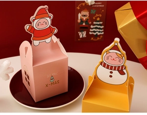 Detailed view of pink Christmas gift box with 'Best Wishes' and handle on festive plate