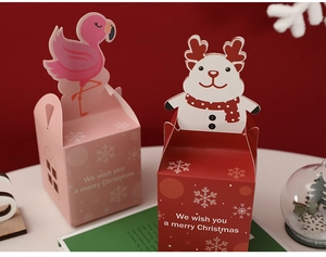 Close-up of festive Christmas apple gift boxes in red and pink with reindeer cutout
