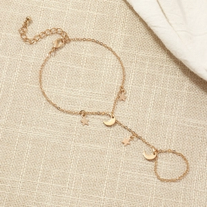 Detailed view of gold chain hand harness featuring delicate star and crescent moon charms