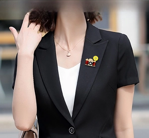 Close-up of vintage camera brooch with yellow flash on a black suit lapel