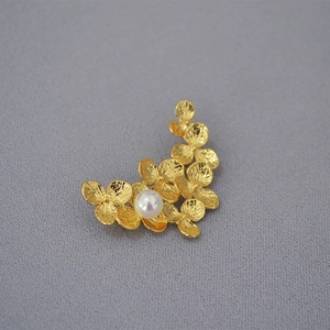 Elegant gold brass leaf brooch with textured petals and a centered white pearl accent