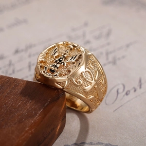 Close-up of golden men's ring with detailed dragon relief and vintage texture