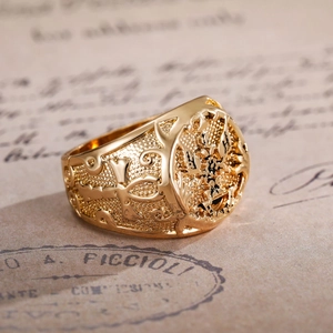Close-up of vintage gold eagle ring with intricate relief engraving and cross pattern