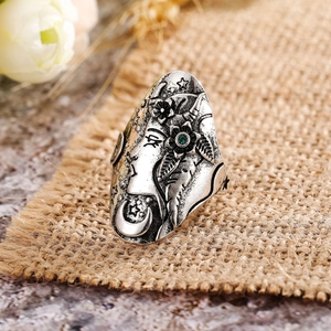 Primer plano de anillo plateado vintage grabado con luna estrellas y gema verde en yute