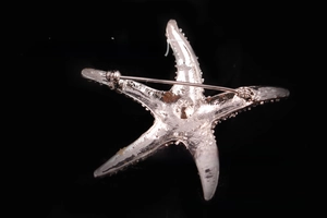 Detailed close-up of the rotating safety pin closure on the back of the starfish brooch