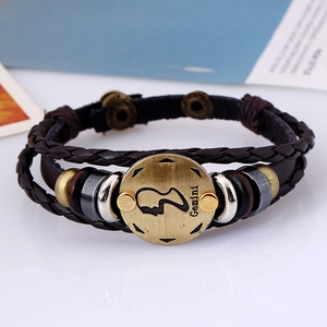 Detailed close-up of a braided brown leather Gemini zodiac bracelet with bronze charms