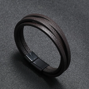 Macro detail of brown multilayered leather bracelet with black magnetic metal clasp