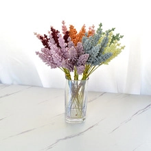 Close-up of colorful artificial flower bouquet in a transparent square glass vase
