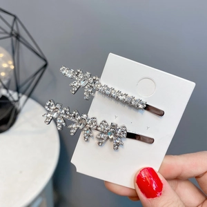 Detail of silver alloy hair clips with sparkling rhinestones and bowknot designs