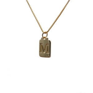 Elegant gold square pendant necklace with embossed letter M on a white background