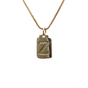 Close-up of gold box chain necklace featuring a rectangular pendant engraved with letter Z
