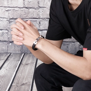 Men's black braided leather bracelet with silver stainless steel chain link on male wrist