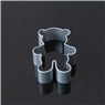 Macro view of a bear-shaped metal cookie cutter on a dark reflective surface