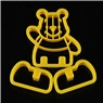 Detail view of a yellow plastic bear-shaped cookie cutter for DIY baking on black background
