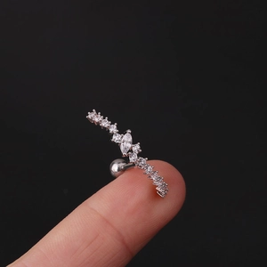 Macro shot of a silver cartilage stud with marquise crystals held on a fingertip