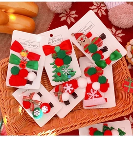 Détail d'un lot de barrettes de Noël avec nœuds et Père Noël sur fond de tricot rouge festif
