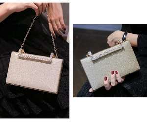 Detail of champagne glitter evening clutch bag with sparkling rhinestone top trim and chain