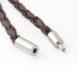 Macro detail of brown braided leather cord with silver cylindrical metal plug clasp