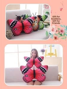 Detail view of plush butterfly pillows in pink and orange with realistic wing patterns