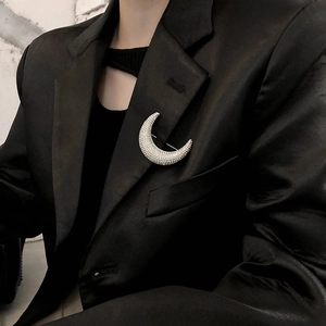 Sparkling silver crescent moon brooch with crystals pinned on a black suit lapel