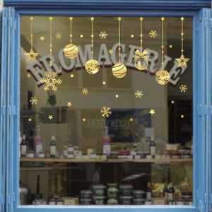 Stickers de Noël dorés avec étoiles et flocons de neige sur une vitrine de magasin
