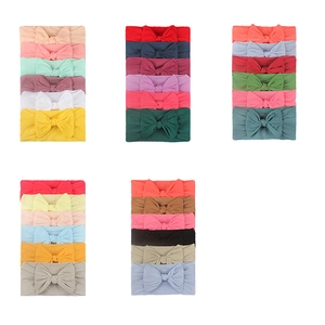 Detail of six soft nylon baby headbands with delicate bow accents in diverse pastel colors